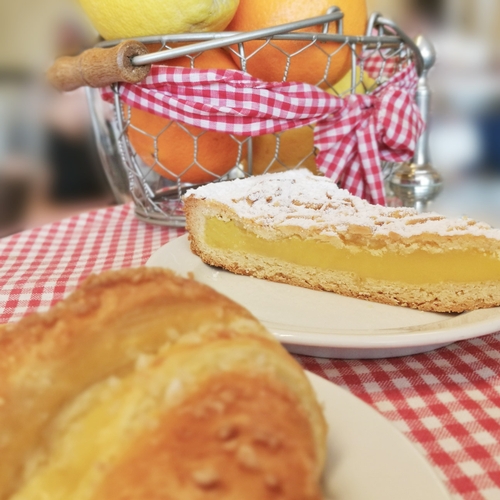 Ein Stück Kuchen liegt auf einem Teller der auf einer rot weiß karierten Tischdecke steht